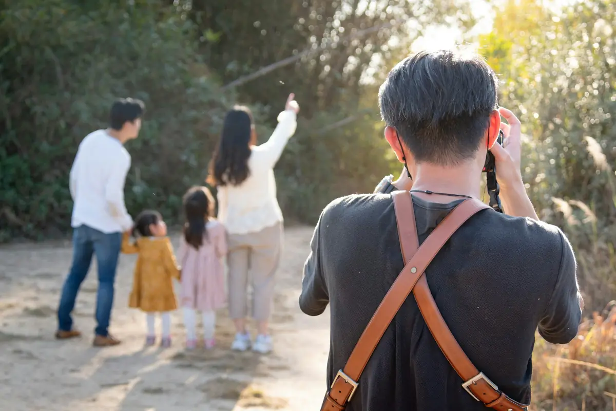 Wren photographing a family on a sandy path, seen from behind